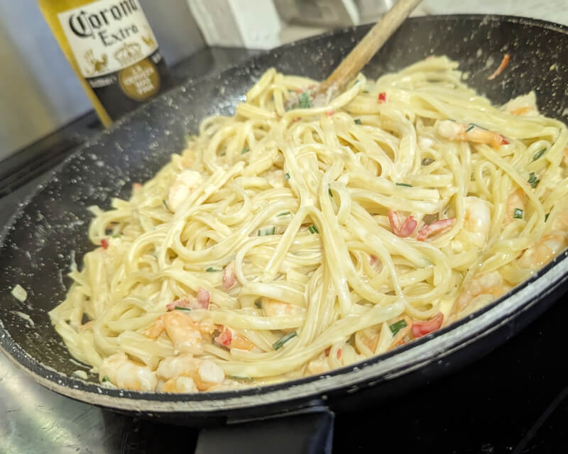 Mixing the linguine into the prawn and chive sauce.